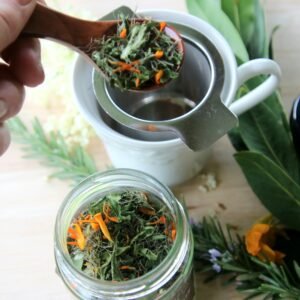 A spoon full of tummy tea being taken from the jar and put in the diffuser